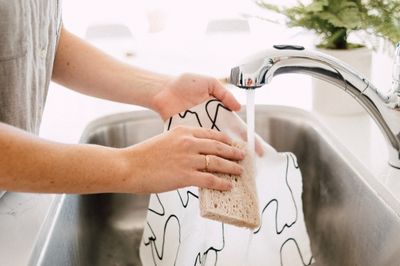 women washing cloth under tap