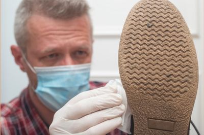 man disinfecting shoes sole