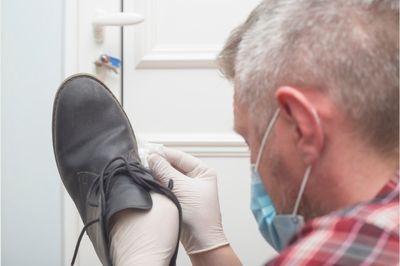 man sanitizing shoes