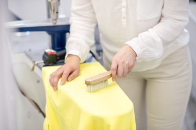 women using lint brush on clothes