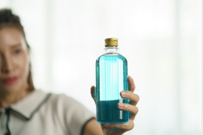 women holding bottle of rubbing alcohol